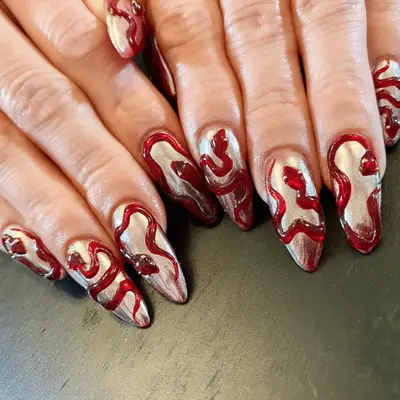 Silver chrome nails with red 3D jelly polish snake art.