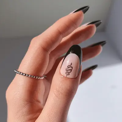 Close up of a black French tip with a black and white snake decal.