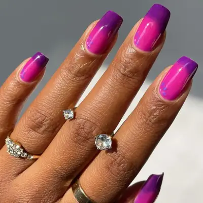 Purple color-shifting manicure with tiny flowers in the corner of each nail.