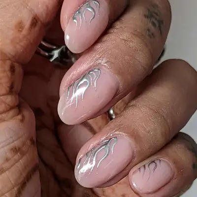 nude nails with silver chrome flame design