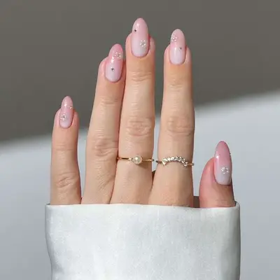 Pink almond-shaped manicure with pearl floral accents