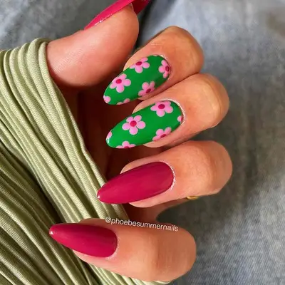 Green and deep pink almond nails with pastel cherry blossom florals on the green nails