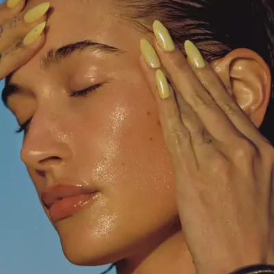 Hailey Bieber with lime green glazed donut, chrome nails.