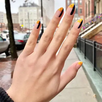 Geometric negative space orange and black nails