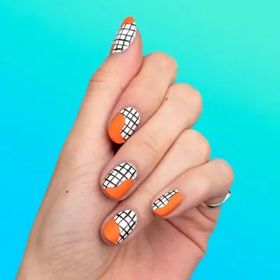 White and black graph patterned nails with orange splotches