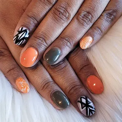 Orange, black, white, and olive gray nails with various designs