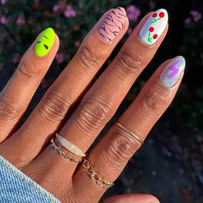 Nail with cherries, animal print, and intergalactic designs