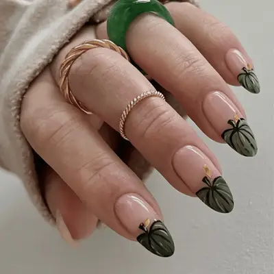 Close up of green French pumpkin nails with a beige base.