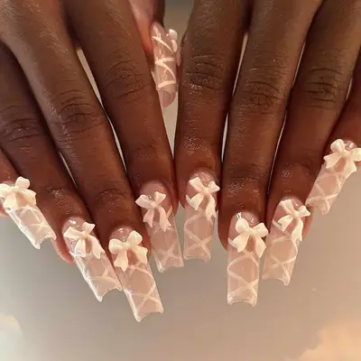 Square-shaped nails with white bows and criss-cross ribbon design