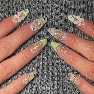 White, green, and baby blue nails with bow, pearl, and rhinestone embellishments