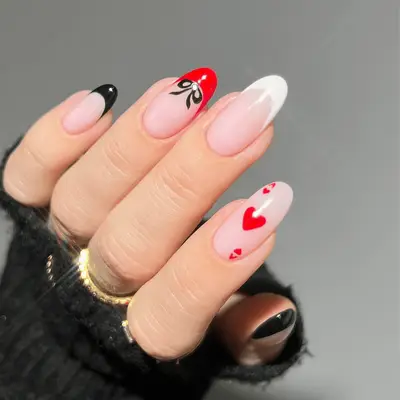Red, black, and white bow nails with an Ace of Hearts design detail