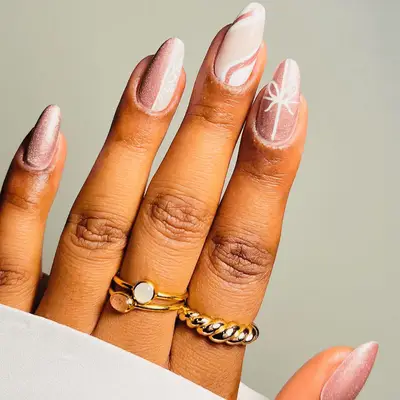 Pink manicure with swirls and bow designs