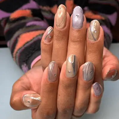 Pastel metallic nails with silver lines and rhinestones
