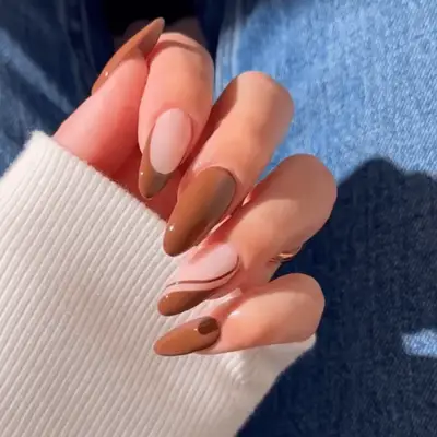 Brown and nude nails with French tips and swirl designs