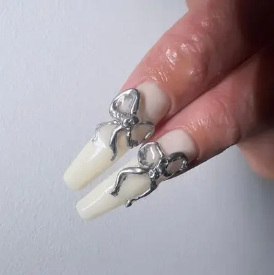 long white nails accented with chrome builder gel bows