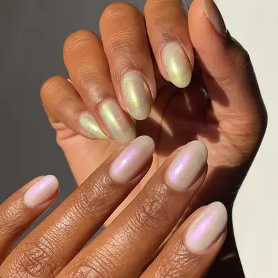 A chrome manicure in two shades of white, different polishes on each hand
