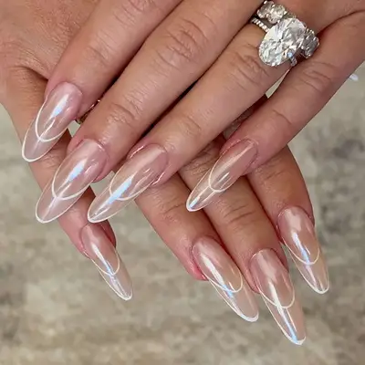 a nude chrome manicure with negative space outlined white tips