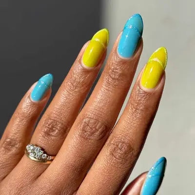 A yellow and blue manicure with negative space French tips