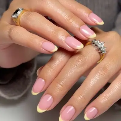 A simple yellow French manicure with a chrome glaze