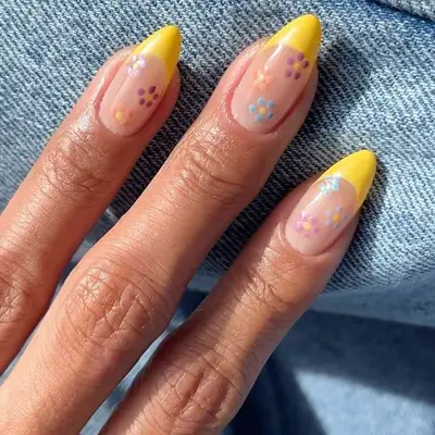 A yellow French manicure with flower details
