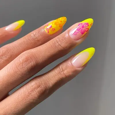 A yellow French manicure with hibiscus details