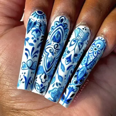Long coffin nails with white base and baby blue porcelain nail art