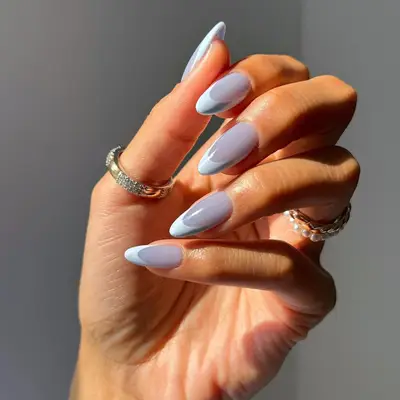 Almond-shaped nails with blue base polish and baby blue french tips