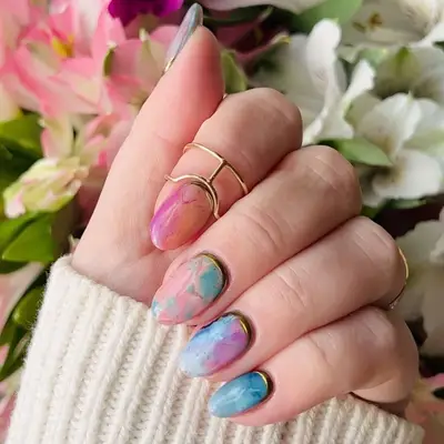 Short pastel watercolor marble nails in shades of pink, orange, blue, and purple