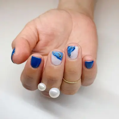 Blue marble diagonal nails with an ashy white base 