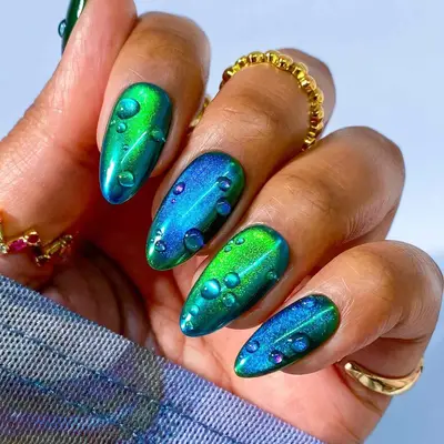 a blue and green manicure with 3d dewdrops