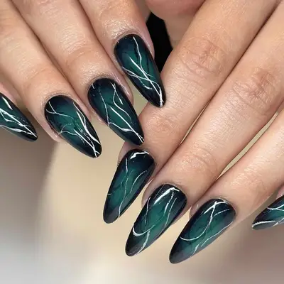 a dark teal manicure with silver chrome stripes