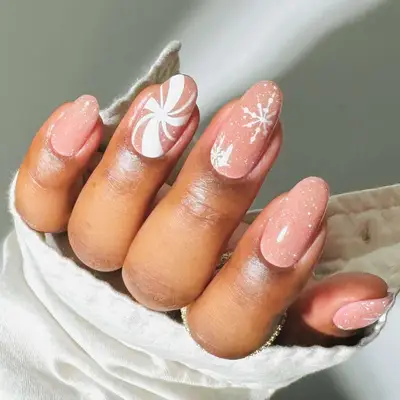 a neutral glittery pink manicure with candy cane and snowflake details