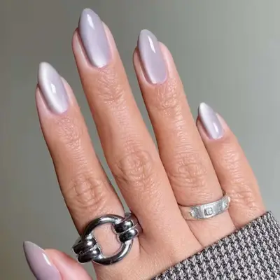 Hand displaying polished nails with metallic rings