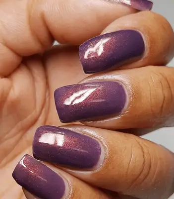 Mocha colored nails on hand with gold rings