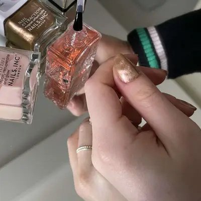 Close up of top coat being painted on a nail