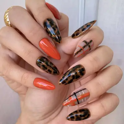 Cheetah print and plaid manicure with orange accents.