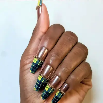 Gold manicure with long yellow plaid tips.