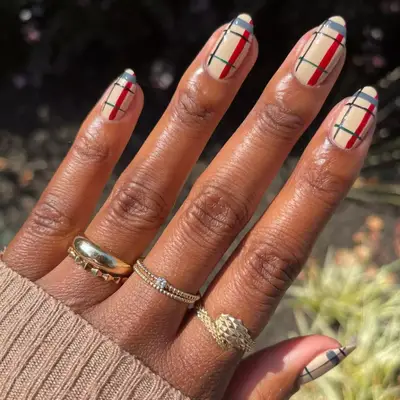 Red, gray, green, and black plaid on a nude base manicure.