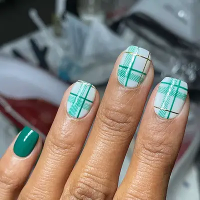 Ultra-short coffin nails with green and white plaid design and solid green accent nail