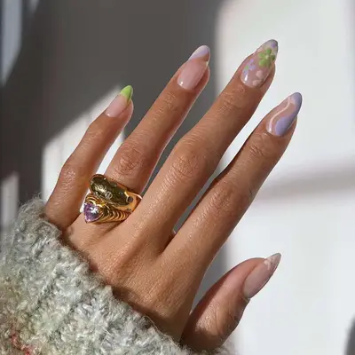 a pastel manicure with flowers, swirls, and french tips