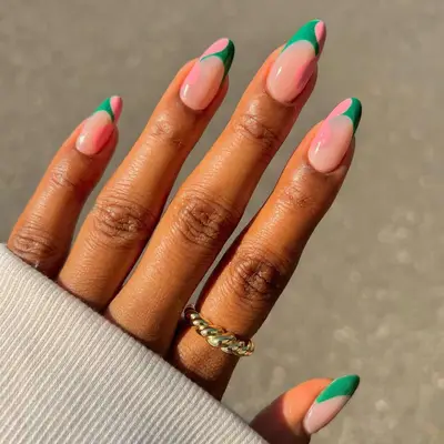 a green french manicure with pink blob details