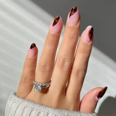 Model with pink nails with a lavender swirl and tortoiseshell detail