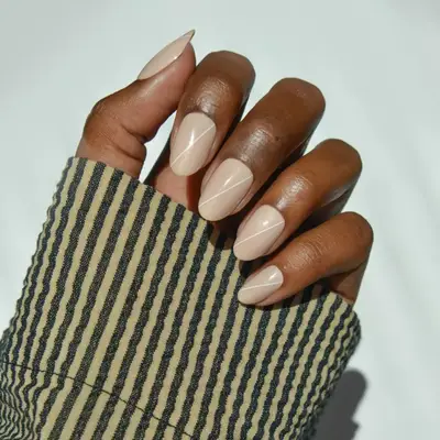 Model with beige nails with a white line