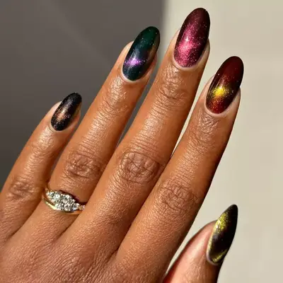 Model with cat eye nails in navy, violet, maroon, yellow, and green