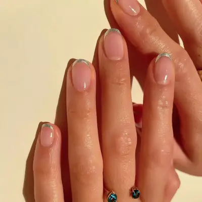 Model with bare nails and a silver chrome French tip