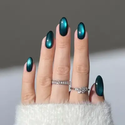 Model with nails in a teal cat eye design