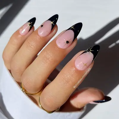 Gold stars on black French tip nails