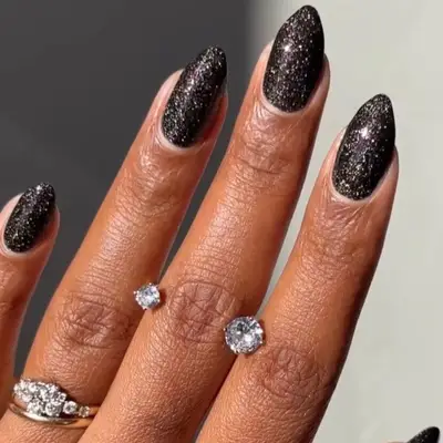 Almond-shaped black nails with glitter