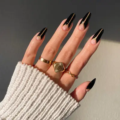 Exaggerated black French tips with gold to accent