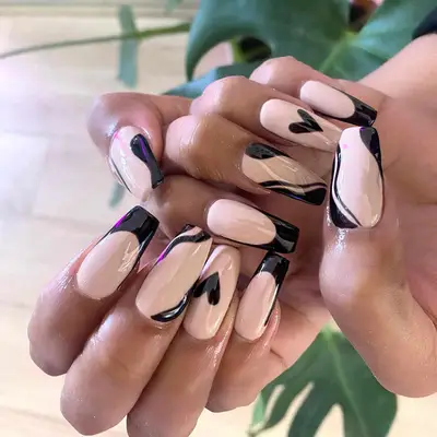 Square-shaped acrylic nails with abstract black waves, French tips, and heart designs